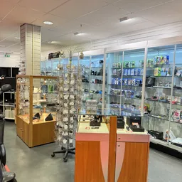 Winkelbinnenruimte met glazen vitrines, houten displaykasten en wandkasten vol met diverse artikelen