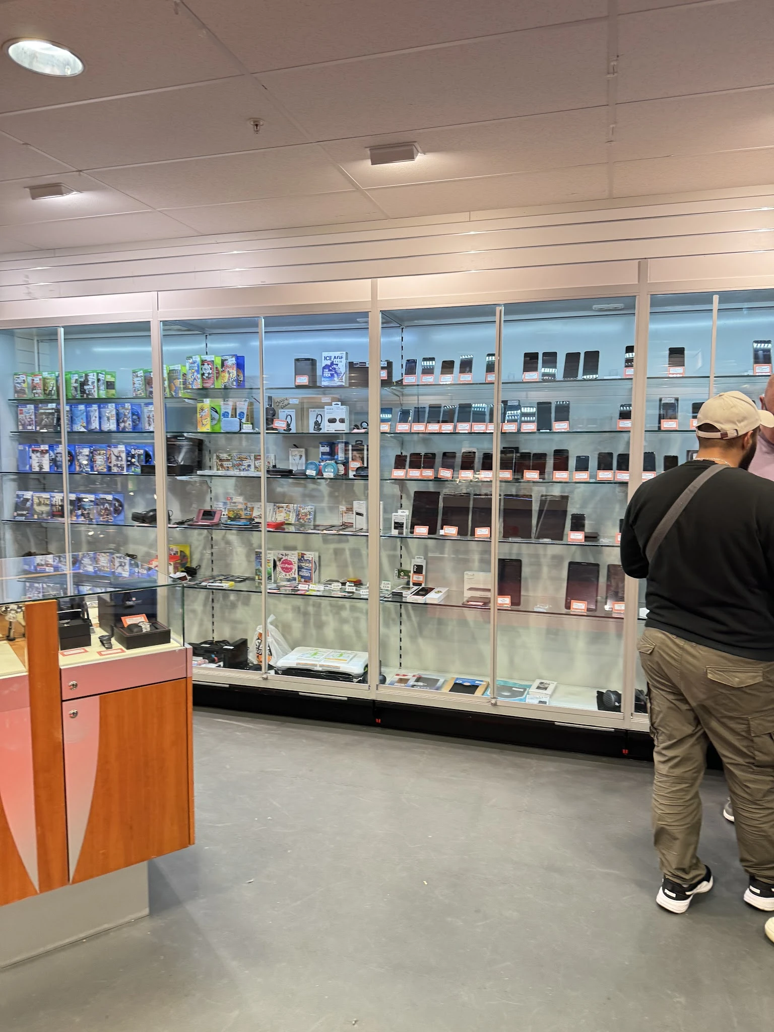 Glazen vitrinekast met uitgestalde mobiele telefoons en elektronische apparaten in verschillende kleuren
