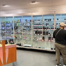 Glazen vitrinekast met uitgestalde mobiele telefoons en elektronische apparaten in verschillende kleuren