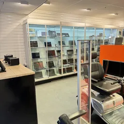 Glazen vitrinekast met elektronische apparaten en computers uitgestald in de winkel