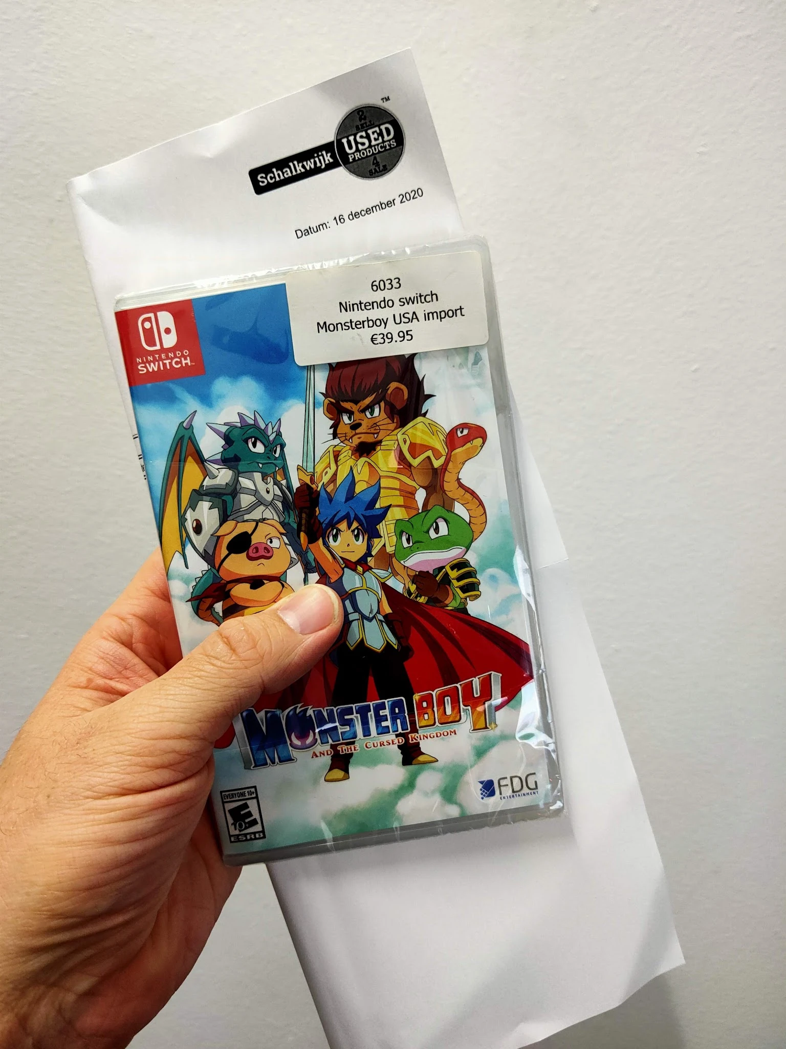 Nintendo Switch-spel Monster Boy and the Cursed Kingdom in verpakking, gehouden in hand