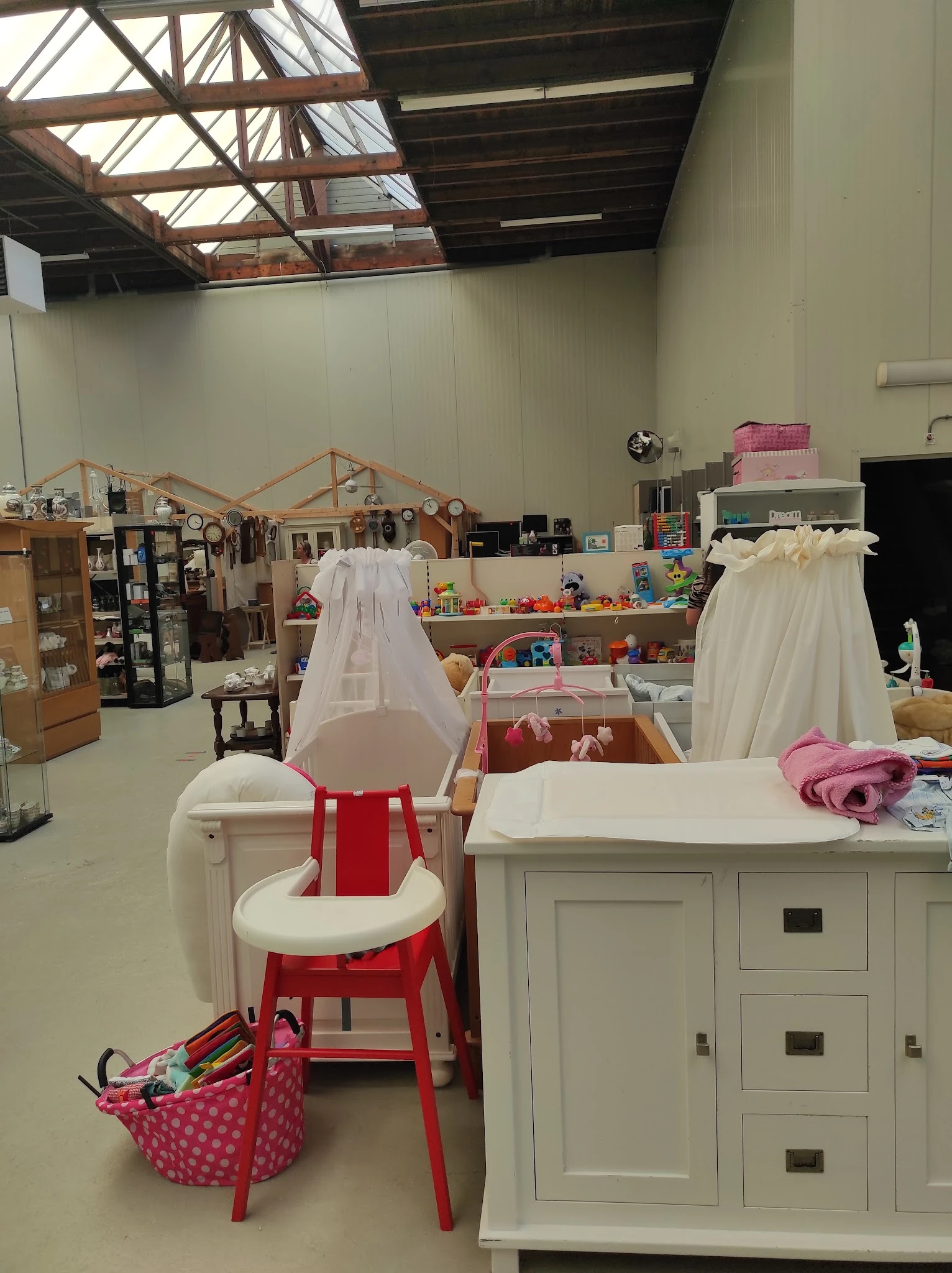 Winkelinterieur met kindermeubels, speelgoed en textiel op tafels en stellingen