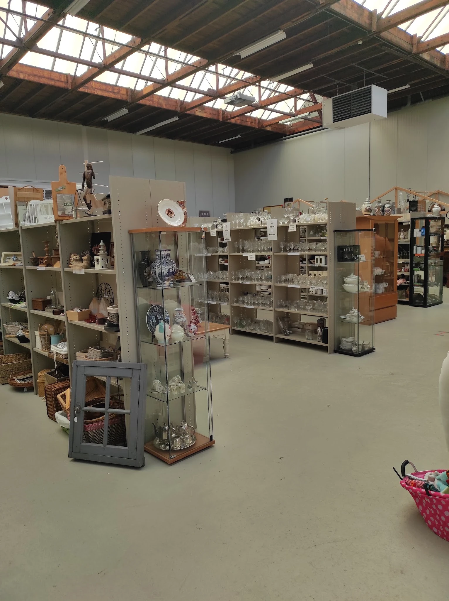 Winkelinterieur met diverse stellingen en vitrines vol huishoudartikelen en decoratieve spullen