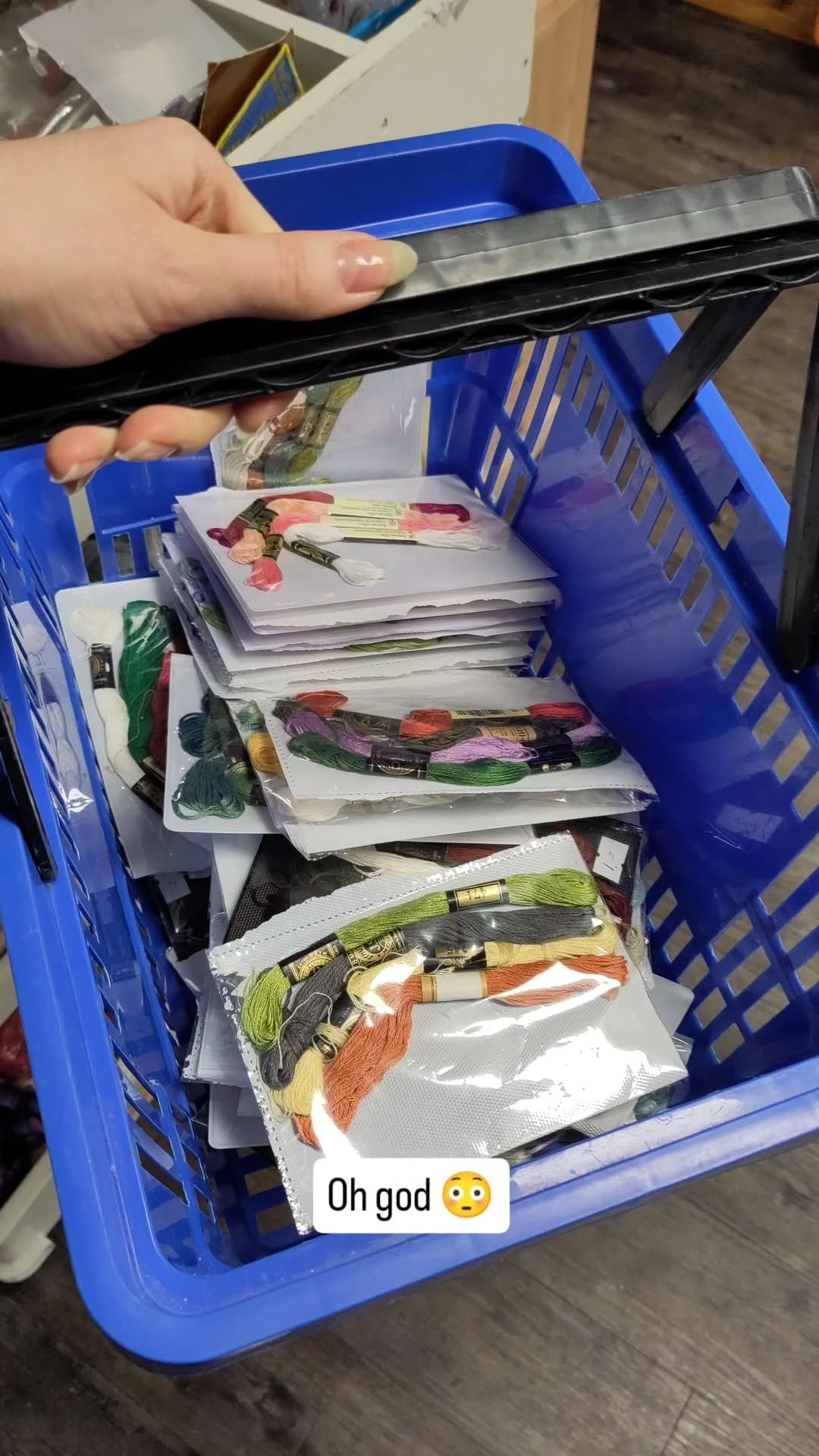 Blauwe krat met gestapelde vellen papier waarop gedroogde bloemen en planten zijn geplakt