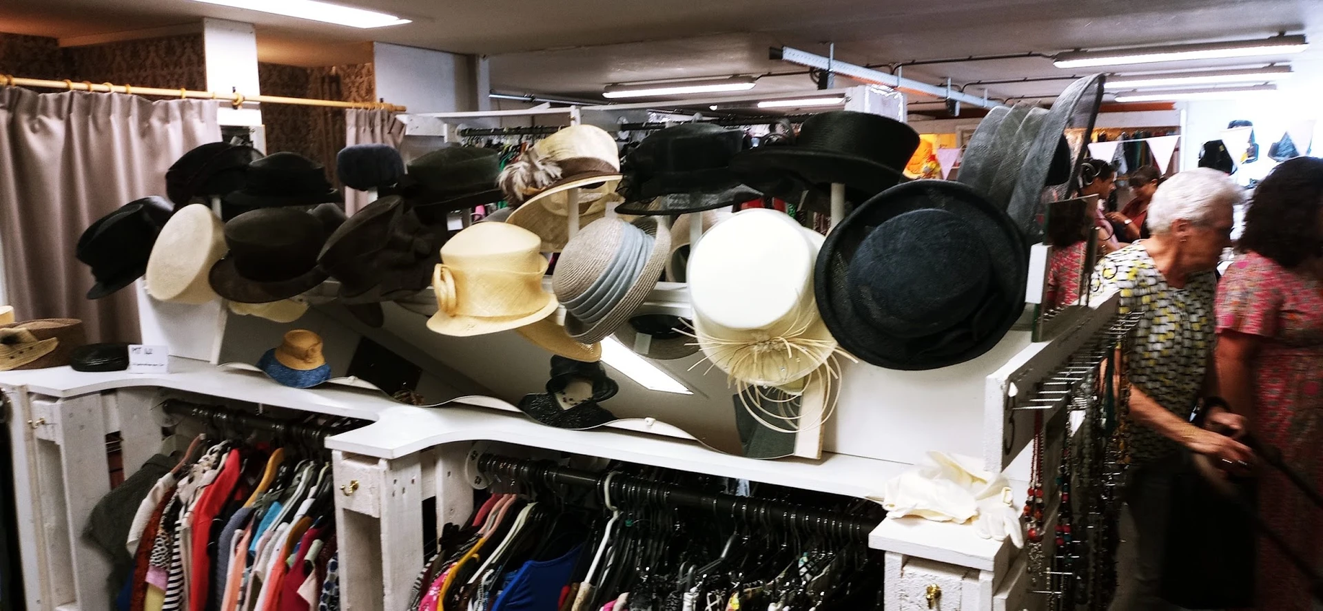 Displaypop met diverse hoedjes en petten in verschillende kleuren en stijlen op een verkaufstand