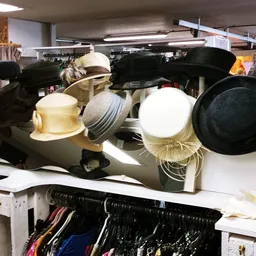 Displaypop met diverse hoedjes en petten in verschillende kleuren en stijlen op een verkaufstand