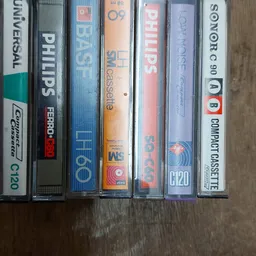 Rij van cassettebandjes in plastic hoezen op houten ondergrond