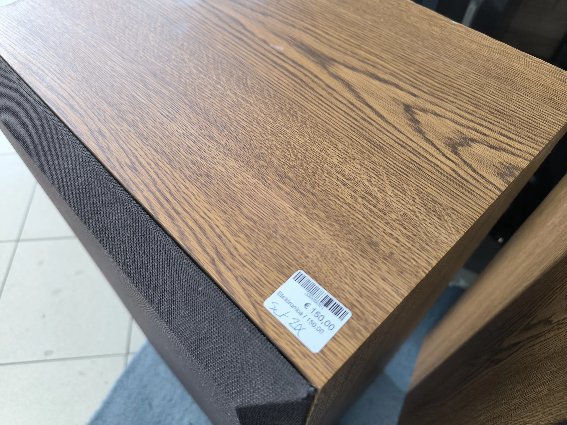 Houten tafel of meubel met prijssticker, grijs stoffen zijpaneel zichtbaar