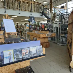 Winkelvloer met diverse stellingen, merchandise en uitgestalde artikelen in een kringloopwinkel