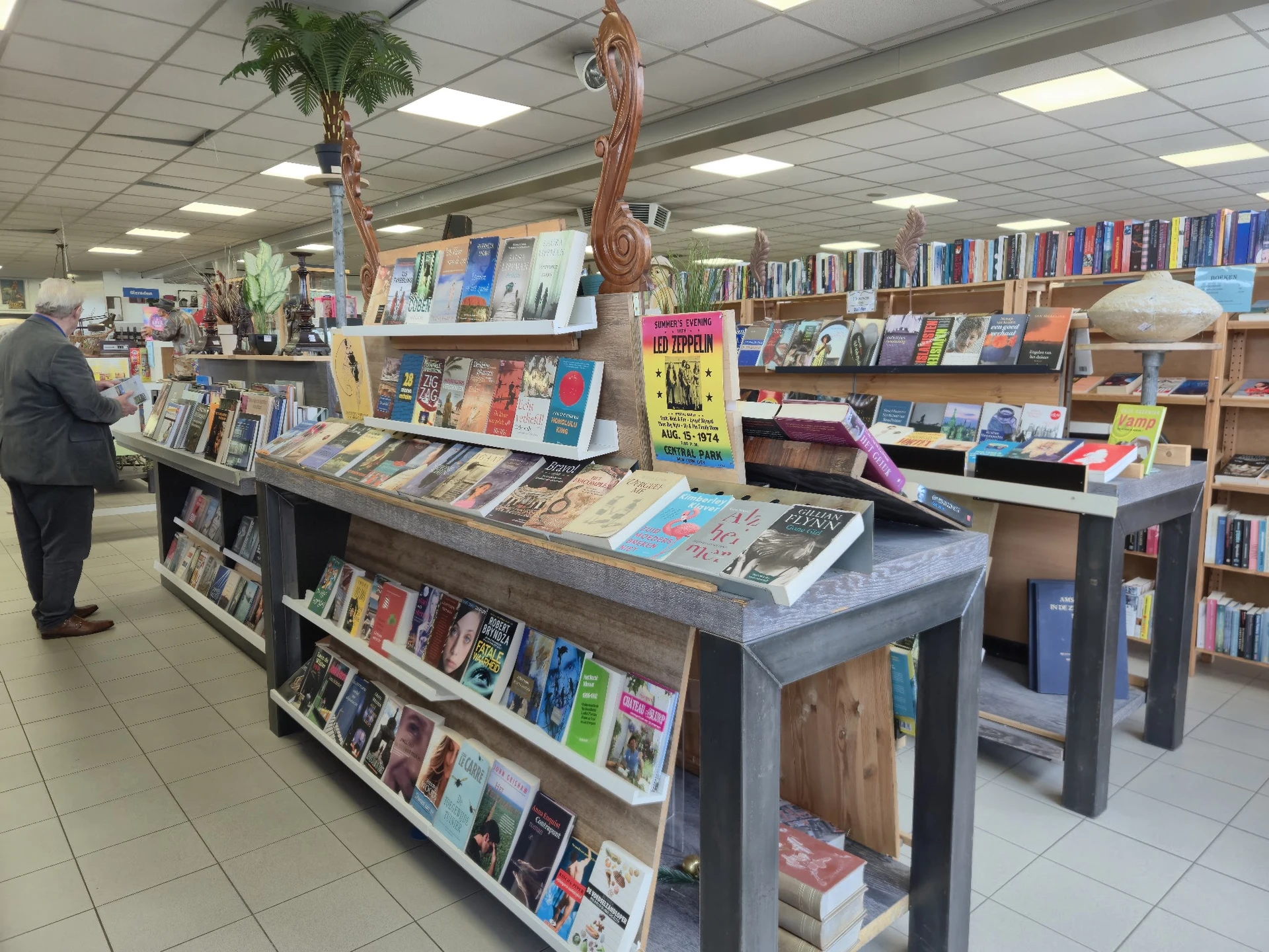 Winkelvloer met boekenrekken en displaytafels met boeken en spullen uitgestald