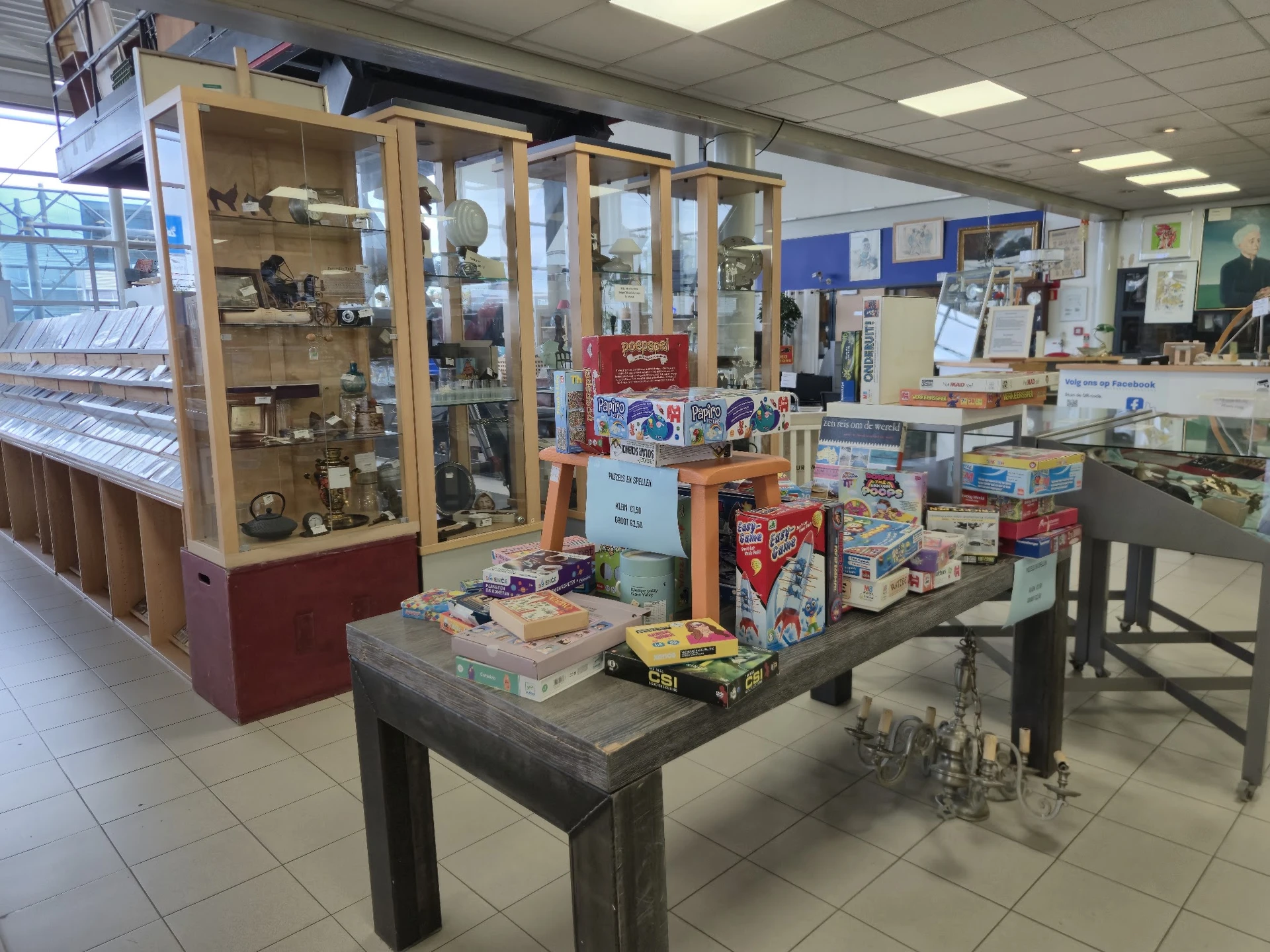 Winkelvloer met glazen vitrines, tafels met diverse tweedehands spullen en kasten met artikelen