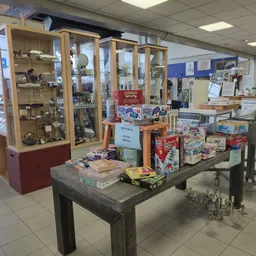 Winkelvloer met glazen vitrines, tafels met diverse tweedehands spullen en kasten met artikelen