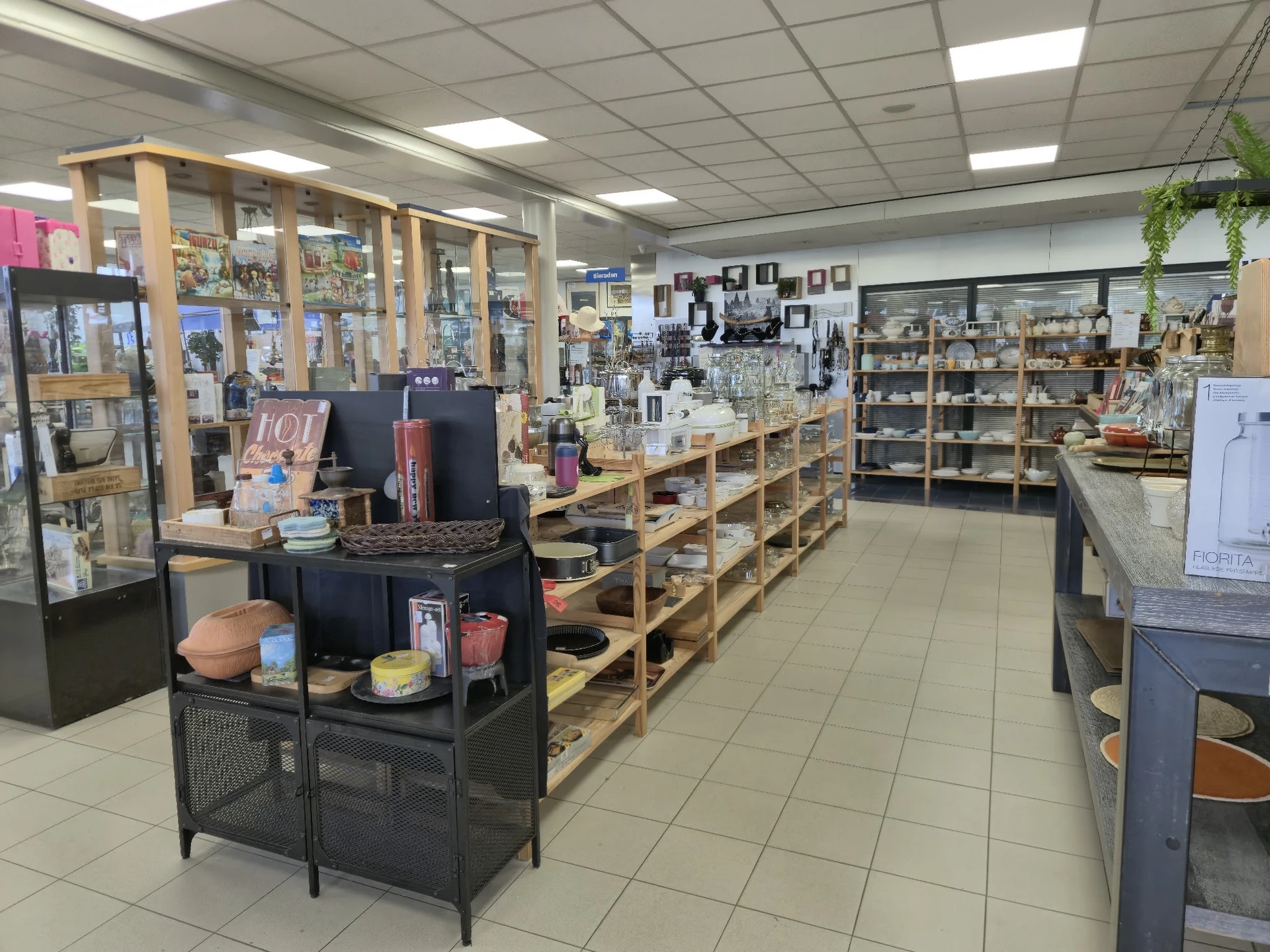 Winkelvloer met houten stellingen vol huishoudelijke spullen, decoratie en overig aanbod