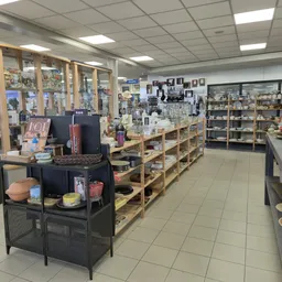 Winkelvloer met houten stellingen vol huishoudelijke spullen, decoratie en overig aanbod