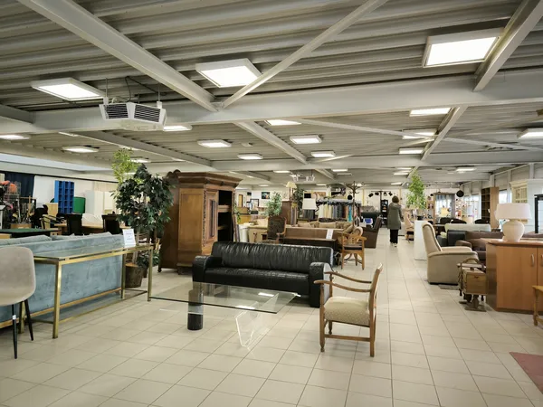 Ruim interieur van kringloopwinkel met diverse meubels, zithoeken en artikelen uitgestald
